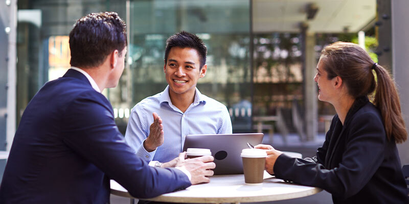 Group of young professionals sitting at a cafe, talking
